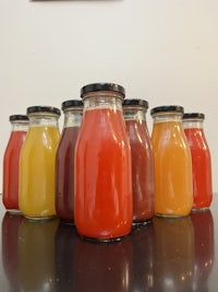 a group of jars of juice sitting on top of each other